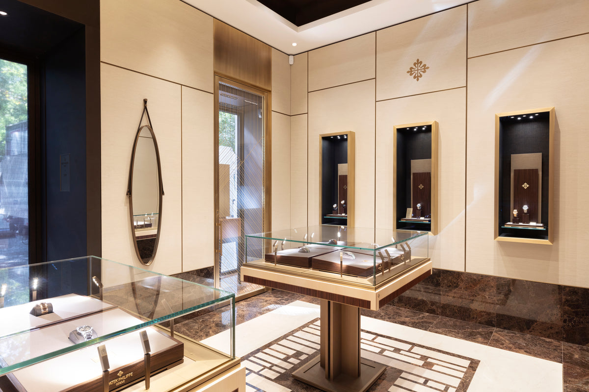 Luxury jewelry display case in a high-end store with reflective surfaces and elegant decor.